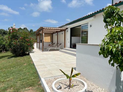 a patio of a house with two chairs at Quinta das Amoras - Au coeur des oliviers in Podentes
