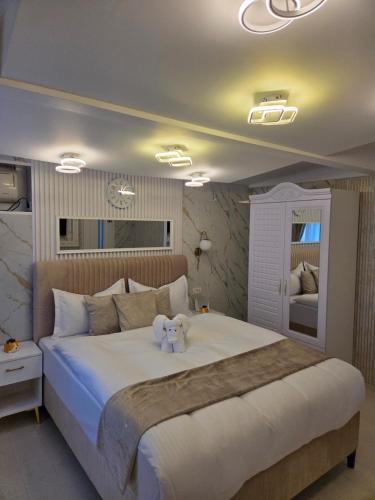 une chambre avec un grand lit blanc avec deux ours en peluche dessus dans l'établissement Iancu Jianu Premium Stay Apartment, à Bucarest