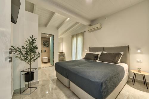 a bedroom with a bed and a potted plant at Marea Luxury Suites in Koríthion