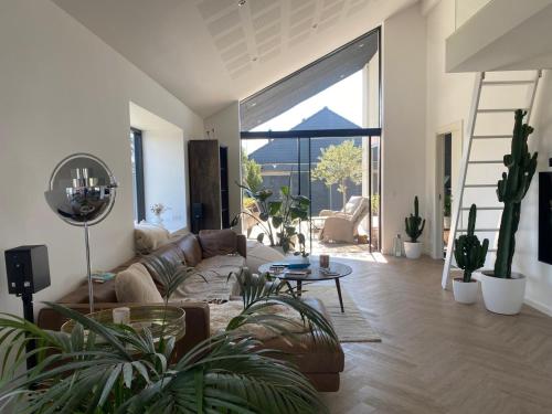 a living room with a couch and some plants at Villa med jacuzzi in Hørning