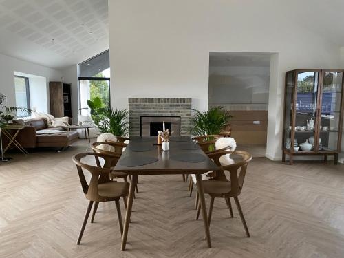 a living room with a table and a fireplace at Villa med jacuzzi in Hørning