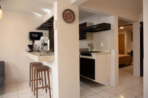 a kitchen with a clock on a wall in a room at Departamento Carrera in San José de Malpaso