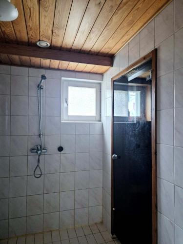 a bathroom with a shower and a black door at Villa Mosahiisi Charming Poolside Getaway in Helsinki