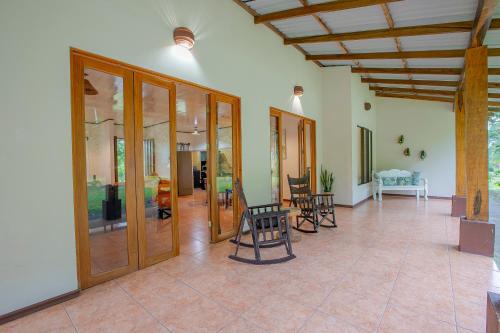 a living room with wooden doors and chairs on a tile floor at Casa Ceiba in San Francisco