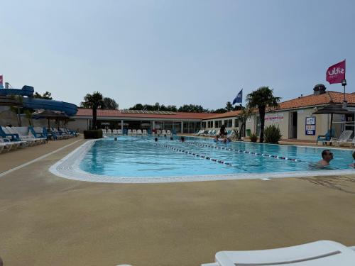 - une piscine dans un complexe avec des personnes dans l'établissement Mobilhome Les Mathes Merveilla 2, aux Mathes
