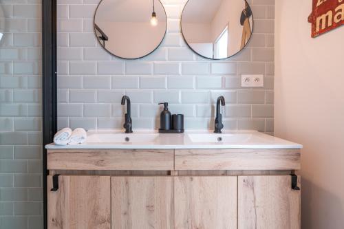 une salle de bain avec deux lavabos et un miroir dans l'établissement Le Loft vintage YourHostHelper, à Sète