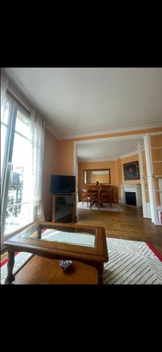 un salon avec une table et un piano dans l'établissement Appartement avec Terrasse 14 ème, à Paris