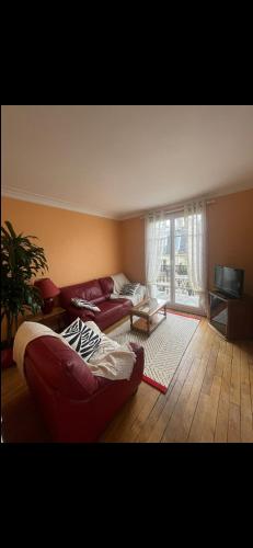 a living room with a red couch and a television at Appartement avec Terrasse 14 ème in Paris