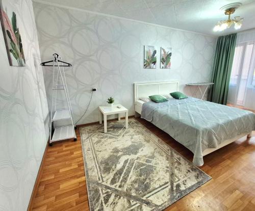 a bedroom with a bed and a ladder and a rug at 1 к квартира в Центре Мухита д 128 in Uralsk