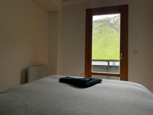 a bed in a room with a large window at Candanchu Maitea in Candanchú