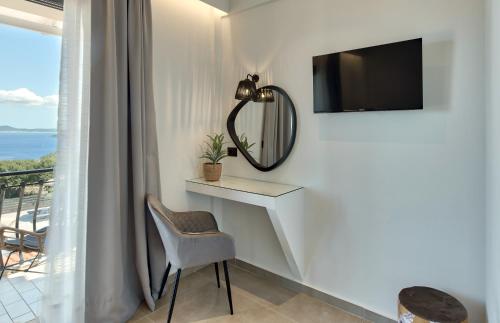 a room with a table and a mirror and a chair at Marea Luxury Suites in Koríthion