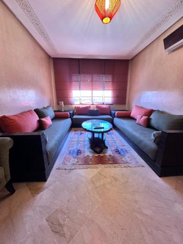 a living room with a couch and a table at Central Gueliz Apartment Bright & Peaceful in Marrakech