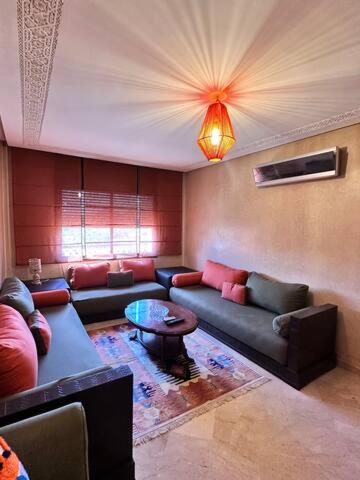 a living room with a couch and a table at Central Gueliz Apartment Bright & Peaceful in Marrakech
