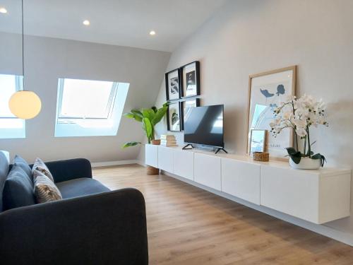 ein Wohnzimmer mit einem TV auf einem weißen Schrank in der Unterkunft Príncipe Boutique apartments in Vigo