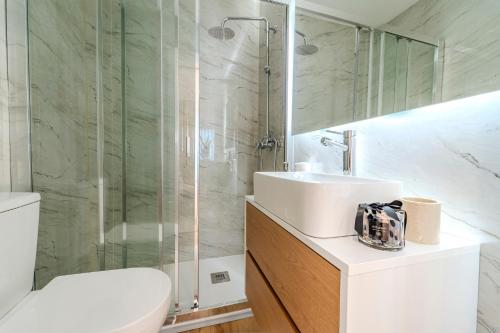 a bathroom with a toilet and a sink and a shower at Seventy Four House in Braga