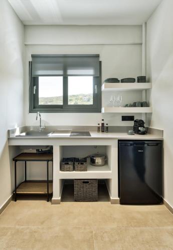 a kitchen with a sink and a window and a dishwasher at Marea Luxury Suites in Koríthion