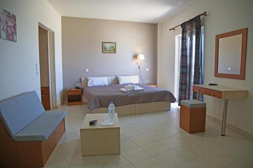 a hotel room with a bed and a chair and a table at Hotel Sea Breeze in Sitia