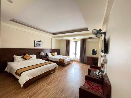 サパにあるSapa Tulip Hotelのベッド2台と薄型テレビ付きのホテルの部屋