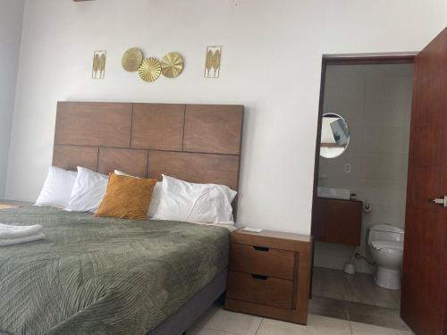 a bedroom with a bed and a bathroom with a mirror at Los Arcos Hottel Boutique in Morelia