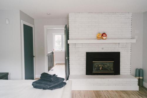 a white brick fireplace in a room with a bed at Sandbanks Cottage on Sheba's Island - 5 min drive, pet friendly in West Lake