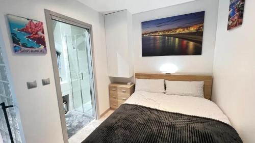 une chambre avec un lit avec un tableau sur le mur dans l'établissement Appartement moderne & calme proche mer et centre, à Nice