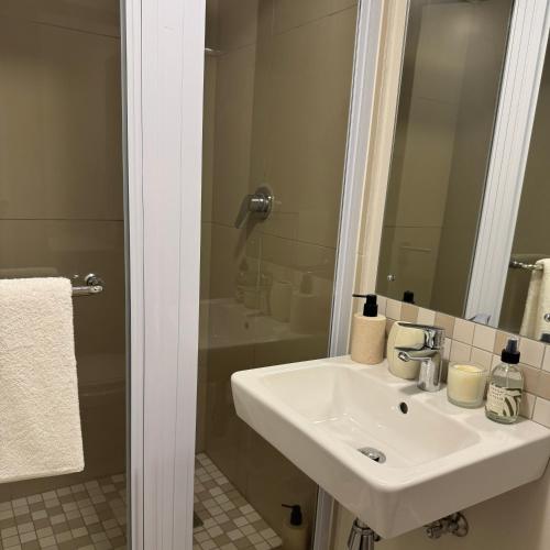 a bathroom with a white sink and a shower at Casa Vita Umhlanga in Durban