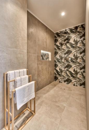 a bathroom with a towel rack and a wall with a mural at Marea Luxury Suites in Koríthion