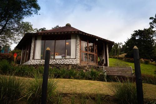 a small house with a window in a field at LasNubes EcolodgeNubes Ecolodge in Santa Elena