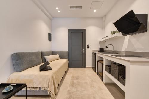 a living room with a couch and a kitchen at Marea Luxury Suites in Koríthion