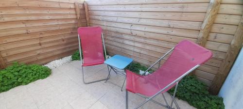 deux chaises roses et bleues assises dans un jardin dans l'établissement Lou pastre, à Saintes-Maries-de-la-Mer