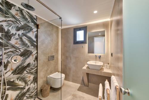 a bathroom with a toilet and a sink and a shower at Marea Luxury Suites in Koríthion