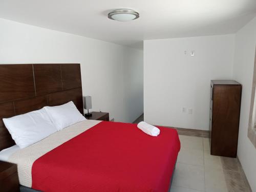 a bedroom with a bed with a red and white blanket at Los Arcos Hottel Boutique in Morelia