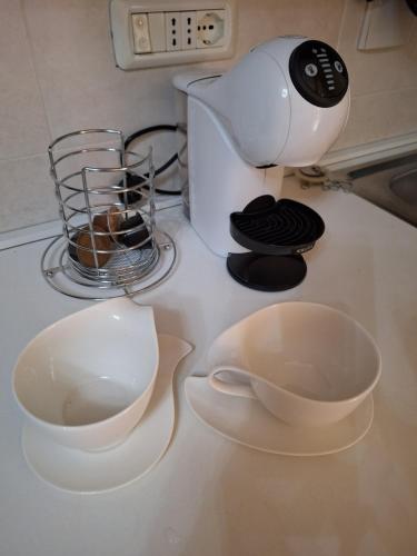 a counter top with two bowls and a coffee maker at Cosy Brosso in Brosso
