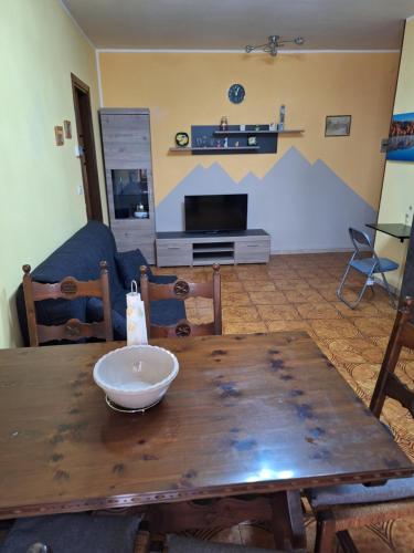 a dining room with a wooden table with a bowl on it at Cosy Brosso in Brosso