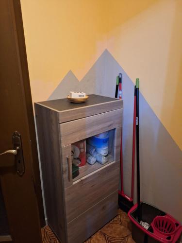 a small wooden cabinet in a room with a refrigerator at Cosy Brosso in Brosso