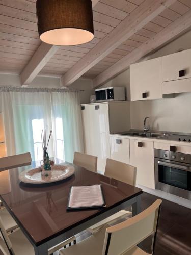 a kitchen with a wooden table and chairs and a dining room at Residence Del Lago in Desenzano del Garda