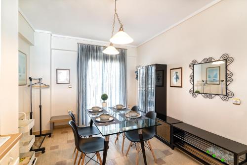 a dining room with a glass table and chairs at Apartment with marina view in Thessaloniki