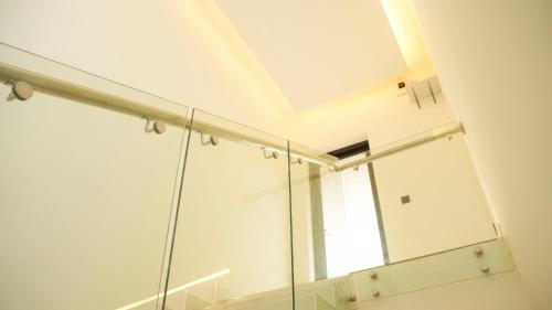 łazienka z przeszkloną kabiną prysznicową z oknem w obiekcie Auddi Homes w mieście Kigali