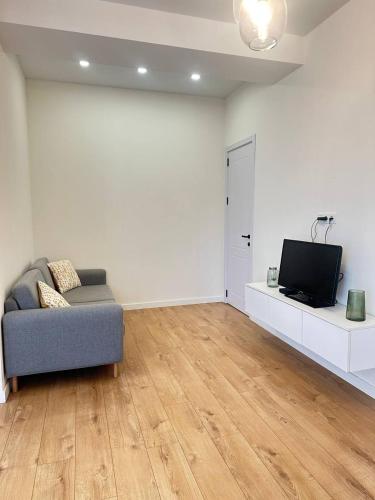 a living room with a couch and a tv at Helihome1 Apartment in Tbilisi in Tbilisi City