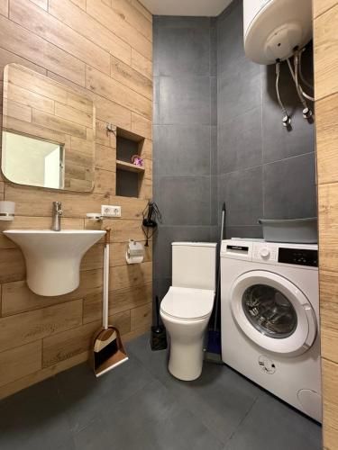 a bathroom with a toilet and a sink and a washing machine at Одесса Калипсо у Моря на Пляже-однокомнатные апартаменты 24 метра in Odesa