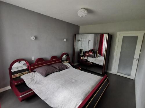 une chambre avec un lit et un grand miroir dans l'établissement Gîte de Malessard, à La Celle-Guénand