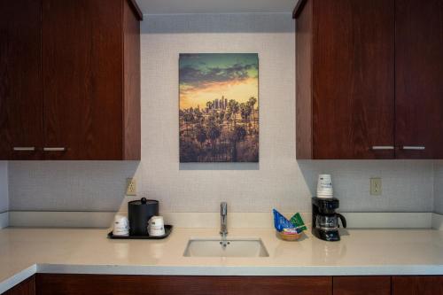 a kitchen counter with a sink and a picture on the wall at SureStay Hotel by Best Western Santa Monica in Los Angeles