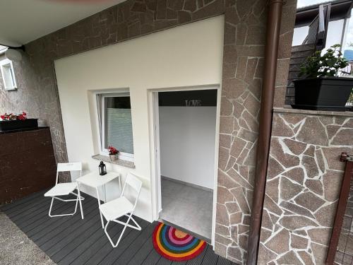 a sliding door on a house with chairs and a table at Apartment JANG in Tolmin