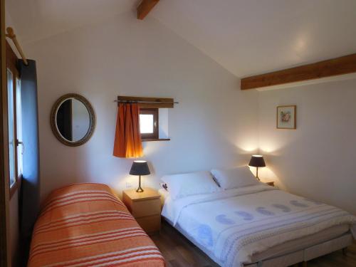 une chambre avec un lit, une fenêtre et un miroir dans l'établissement Rural Holiday Cottage with private pool, à Saint-Blancard