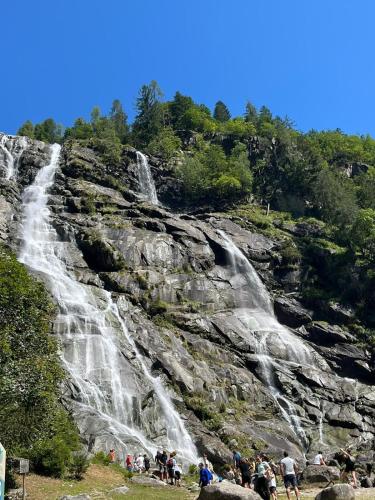 a group of people standing in front of a waterfall at La casa di Nil - Appartamento Volpe in Spiazzo