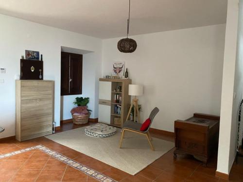 ein Wohnzimmer mit einem Stuhl und einem Schreibtisch in der Unterkunft MAISON FAMILIALE ENTRE MER ET MONTAGNE Lisbonne in São Bartolomeu