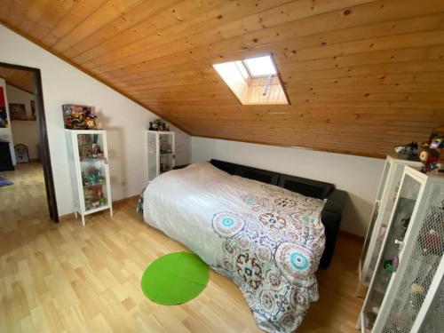 ein Schlafzimmer mit einem Bett auf einem Dachboden in der Unterkunft MAISON FAMILIALE ENTRE MER ET MONTAGNE Lisbonne in São Bartolomeu