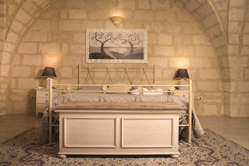 a bedroom with a bed in a stone wall at Suite Cavour Luxury Home Taranto in Taranto