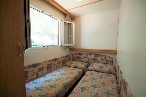 a couch in the corner of a room with a window at Green Village Assisi in Assisi