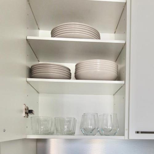 a cupboard with plates and glasses in it at Henniina V Rautatieasema II Private terrace in Oulu